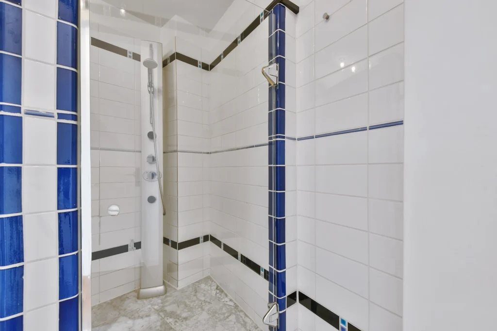 Clean modern shower with blue tile accents showing bathroom tile refinishing results