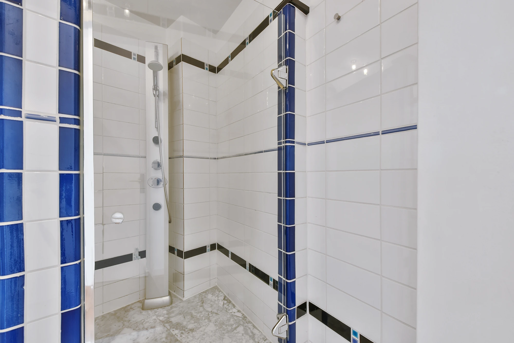 Clean modern shower with blue tile accents showing bathroom tile refinishing results